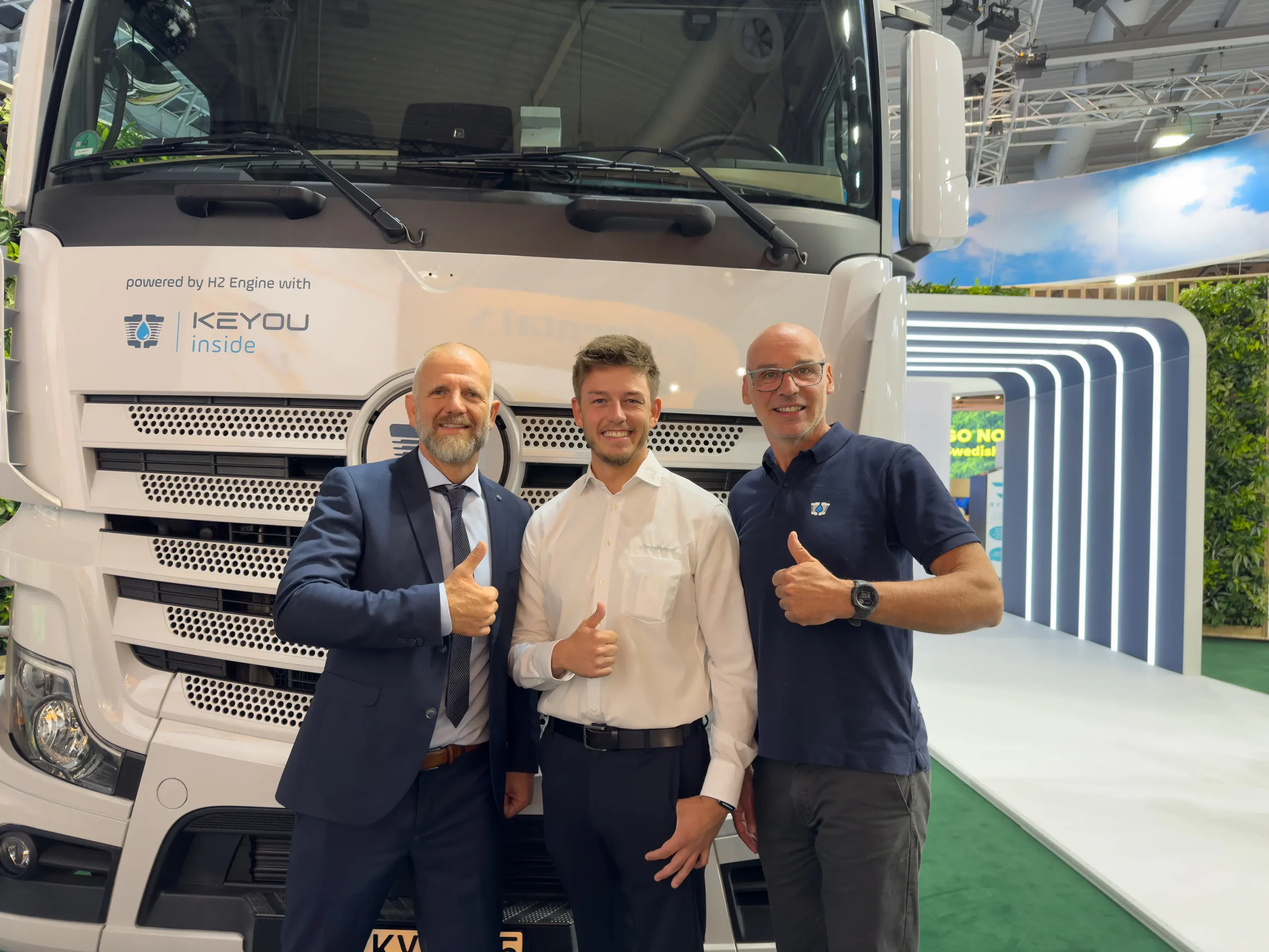 Anlässlich der IAA Transportation in Hannover freuten sich Keyou und Pneuhage vor den neuen Lkw-Modellen auf die künftige Zusammenarbeit. Personen auf dem Bild: Links/rechts: Markus Schneider, COO/CTO von KEYOU und Christian Soethe, Head of Vehicle Solutions von KEYOU; Mitte: Alessandro Fante, Key-Account-Manager Pneuhage Fleet Solution